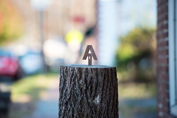 Small "AT" woodcarving decoration made out of a tree stump