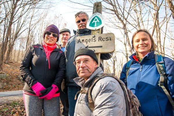 Sonu and hikers pose in front of Angel's Rest trail sign