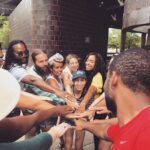 Group uniting with hands in the center before cheering together.