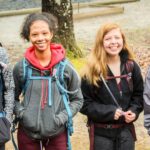 Four youth hikers smiling at the camera