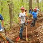 Volunteers use tools along a section of Trail