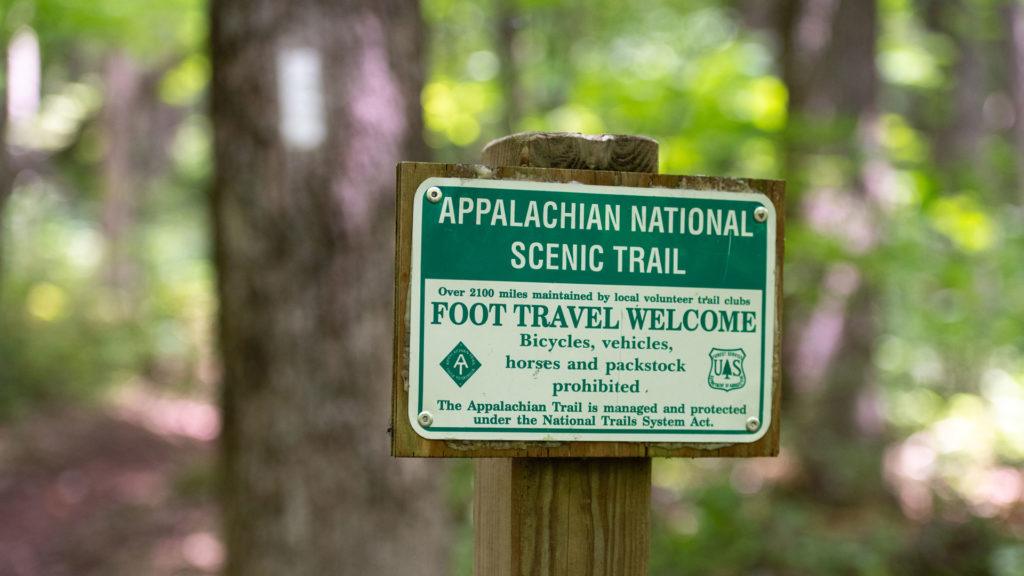 The Appalachian National Scenic Trail sign with a white blaze in the background. Photo by Horizonline Pictures