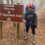 Hiker poses by the A.T. Approach Trail sign
