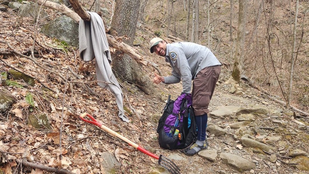 Great Smoky Mountains Ridgerunner collects a blanket left behind on the Trail