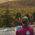 Enjoying a snack with a view of the mountains and fall leaves below
