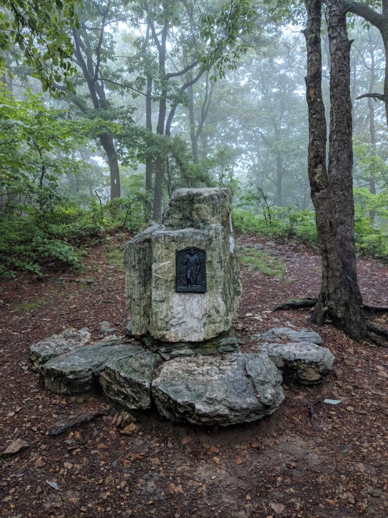 Stone monument with trail mileage