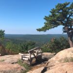 Wooden bench on a rocky outcropping overlooking a scenic view