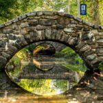 An arched stone bridge and its reflection in the water below