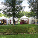 Line of white booths at outdoor festival