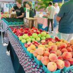 Fresh fruit on tables surrounded by people