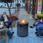 People sitting around a firepit outside a shop