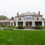 The facade of a stone house on a grassy lawn