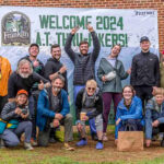 Hikers posing in front of banner; Franklin, NC