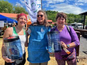 Three women smiling and holding BearVault bear canisters 
