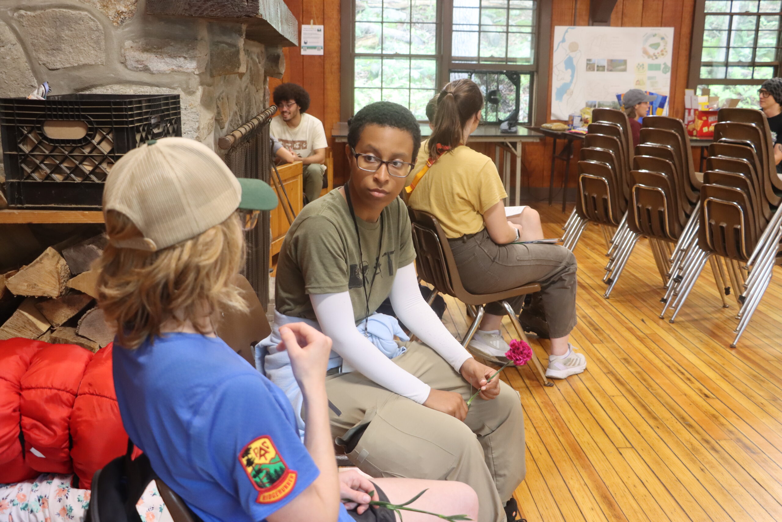 People sitting in pairs, talking to each other, inside a building.