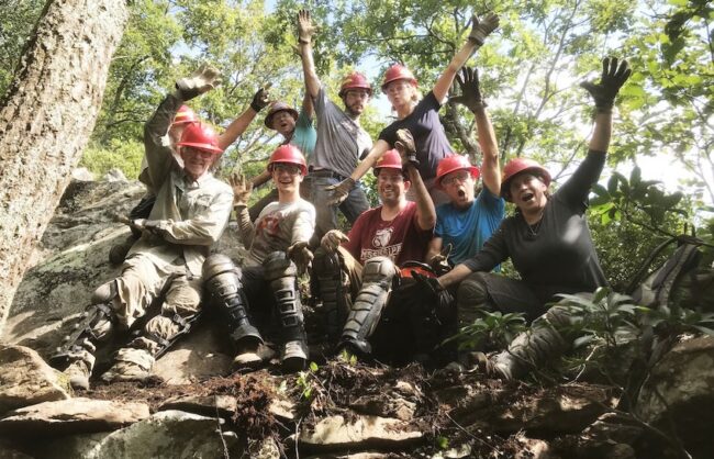 Group of trail volunteers in safety gear posing for photo