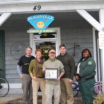 People standing in front of Bikes and Hikes, a business in Blairsville, GA, to recognize it as an A.T. Community™ supporter.