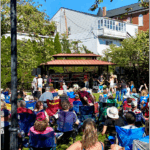 Crowd watching band play under a pavillion