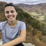 Meagan posing at a valley overlook with colorful fall foliage in the background