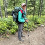 A photo of Appalachian Trail Visitor Center volunteer wearing a backpacking and hiking clothes, standing on a Trail.