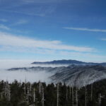 Snowy Smoky Mountain mountains peaking over heavy clouds in the valleys