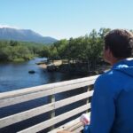 Man standing on Abol Bridge looking at a distant Katahdin