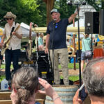 Live band plays on an outdoor stage to an audience