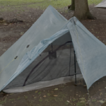 Blue tent sits in a deep puddle of water.