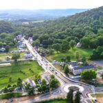 A roundabout and surrounding buildings in Hillsboro, Virginia, set against lush, rolling green hills.”