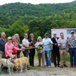 A group of people ready to cut a green ribbon at the new Andy Layne Trailhead