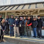 GreyBeard and group of supporters pose against the stone front porch of the Appalachian Trail Conservancy Harpers Ferry Visitor Center.